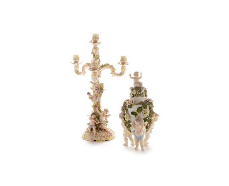 A late 19th Century Volkstedt three-branch candelabra, the base applied with three putti, two playing musical instruments, al