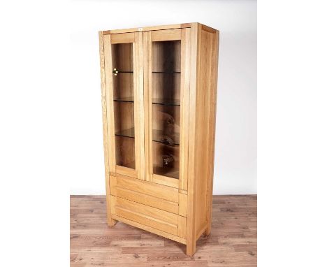 An M&amp;S Samona tall display unit, with two glazed panel doors, opening to reveal three glass shelves, two drawers to the b