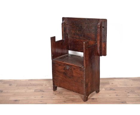 A 17th Century style oak monks bench, with moulded and carved folding top and hinged panel cover to seat, 73 x 48 x80cms high