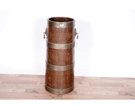 An early 20th Century coopered oak and brass bound stick stand with lion mask and ring handles, 28 x 77cms high.
