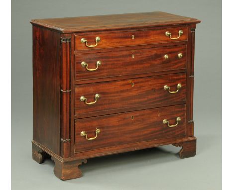 A George III mahogany chest of drawers, with crossbanded moulded edge above four long graduated drawers with brass drop handl