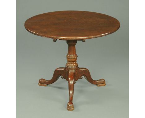 A George III mahogany tripod table, with heavy circular top and bird cage type support raised on three downswept legs termina