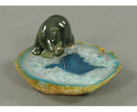 A jade bear with fish, raised on a polished part Geode. Length 10 cm.