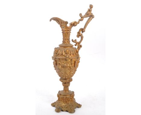 An early 20th century circa bronze spelter decanter jug. With embossed cherub decoration. With curved spout into a tapering b