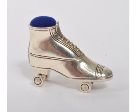 A 20th Century vintage sterling silver pin cushion in the form of a roller skate having dark blue cushion material and moving