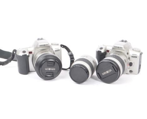 Minolta - Two circa 1999 Minolta Dynax 404si 35mm SLR cameras. The cameras each in silver and black colourway. Each camera wi