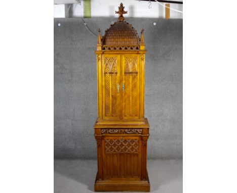 A C.1900 Continental walnut Gothic style domestic shrine, the carved pediment with finials above arched panel doors and base 