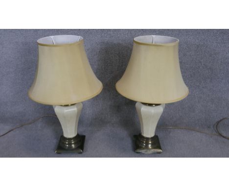 A pair of vintage brass and white crackle glaze ceramic table lamps with cream shades. H.74cm 