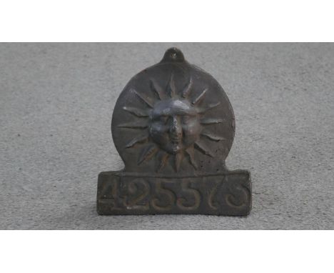 A lead Sun firemark insurance plaque, with rising sun in a disc over rectangular panel and impressed policy number 525573. 