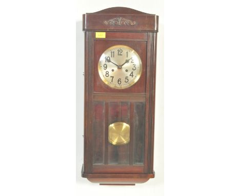 An early 20th century mahogany cased wall clock. The clock having silvered face with Arabic numeral to the chapter ring and p