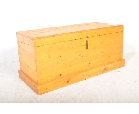 A vintage 20th Century pine trunk. The trunk of rectangular form with a slatted pine hinged top over lock to front and all be