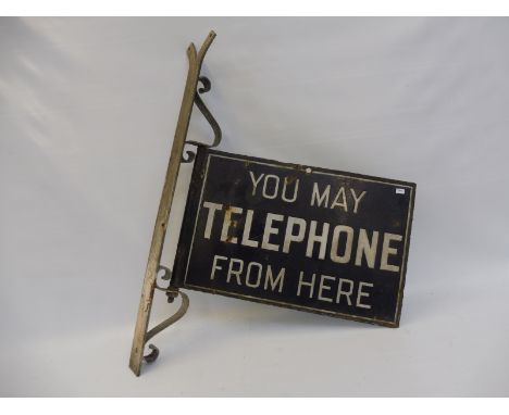 A 'You May Telephone From Here' double sided enamel sign on unusual pivot bracket, a very early example. 