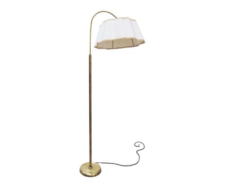 A 1950s brass floor lamp with a reeded column and adjustable cantilever head with shade. The foot with counter balance weight