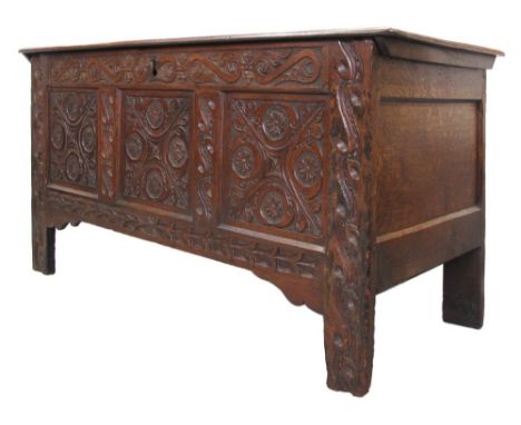 A c19th century English oak three panel coffer chest with carved decoration to front, inner candle box and two small drawers.