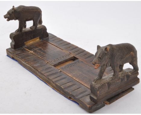 A 20th century German carved wood Black Forest book slide. The bookend having carved bear figures to each end. Measures 30cm 