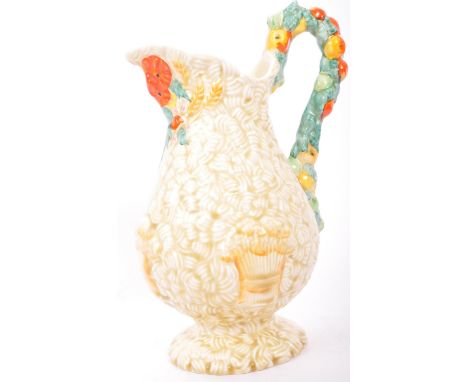 An early 20th century Clarice Cliff ' Celtic Harvest ware '  jug. The decorative jug having printed Clarice Cliff Newport Pot
