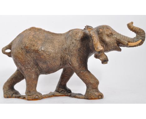 A 20th century carved wood elephant figure. The elephant being modelled in walking position with trunk raised. Measures 22cm 