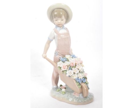 Lladro - A vintage 20th century Spanish porcelain figurine entitled 'Boy with Wheelbarrow of Flowers'. No 1283. Measures 25cm