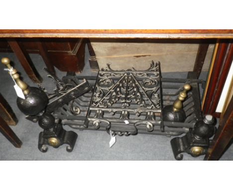 A wrought iron fire basket supported by a pair of fire dogs with brass fittings and a similar screen with attachments