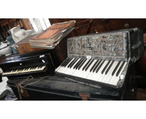 An early 20th century piano accordion with an ebonised case and pine box, another similar by Hohner and a quantity of related