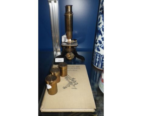 A student's microscope with lenses and books