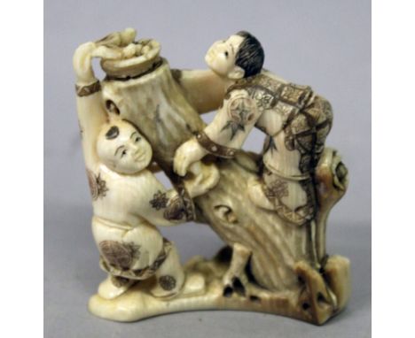 A GOOD QUALITY EARLY 20TH CENTURY SIGNED JAPANESE IVORY OKIMONO, carved in the form of two boys around and on a tree trunk su