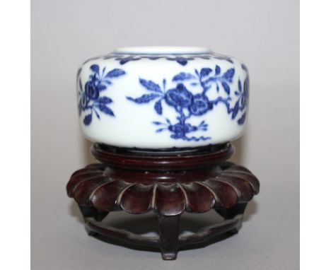 A SMALL CHINESE PORCELAIN JAR, together with a fitted hardwood stand, the sides of the squat body decorated with sprays of pe