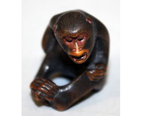A GOOD QUALITY JAPANESE EDO PERIOD WOOD NETSUKE OF A SEATED MONKEY, its fur naturalistically engraved, the side with an inlai