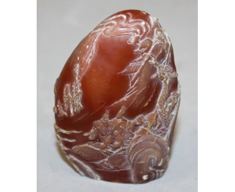 A SMALL CHINESE SOAPSTONE STYLE BOULDER, the sides decorated with figures in a river landscape setting, 2.75in high.