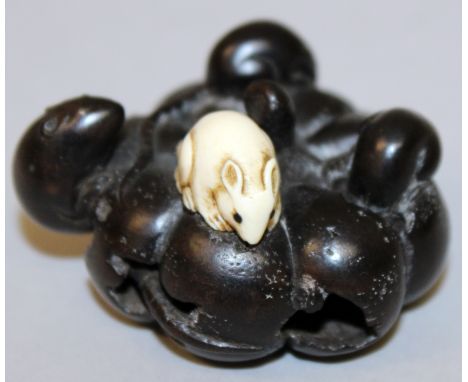 A SIGNED JAPANESE WOOD & IVORY NETSUKE, in the form of a group of rats on a decaying pumpkin, one of the rats carved from ivo