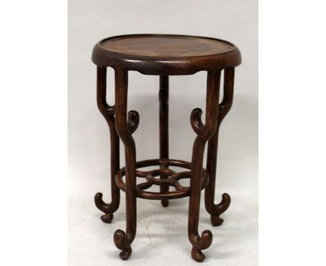 AN EARLY 20TH CENTURY CHINESE CARVED HARDWOOD VASE STAND, supported on five scroll-end feet with a connecting undertier, 5.9i