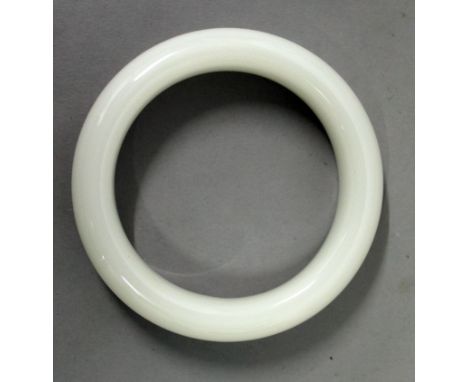 A CHINESE WHITE JADE-LIKE BANGLE, 3.2in diameter, the inner rim 2.3in diameter.