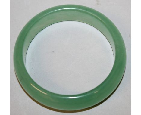A CHINESE GREEN JADE BANGLE, 3in diameter, the inner rim 2.3in diameter.
