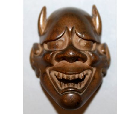 A SIGNED JAPANESE MEIJI PERIOD BOXWOOD MASK NETSUKE OF HANNYA, with horns and with smiling and grimacing expression, the unde