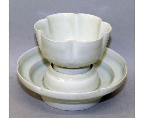 A CHINESE SONG STYLE SHAPED CELADON TEABOWL & STAND, each applied with a pale glaze, each base unglazed, 3.1in high overall, 