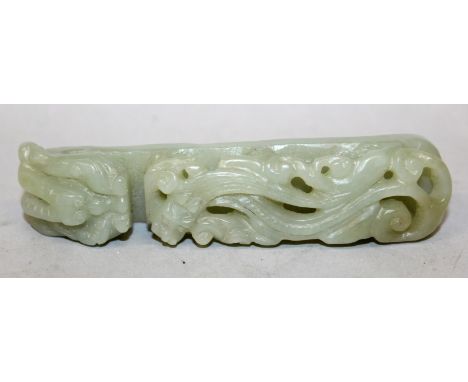 AN EARLY 20TH CENTURY CHINESE CELADON JADE BELT HOOK, the stem pierced and carved in high relief with a sinuous chilong, the 