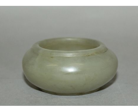 A SMALL 19TH CENTURY JADE BRUSHWASHER, of mottled brownish celadon tone. 2.1is wide at widest point & 1in high.