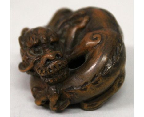 A JAPANESE MEIJI PERIOD BOXWOOD NETSUKE OF A COILED DRAGON, its features and coat naturalistically rendered, 1.6in wide at wi