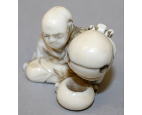 A SIGNED JAPANESE MEIJI PERIOD IVORY NETSUKE OF A SEATED MAN, holding aloft a temple bell, the base with an engraved signatur