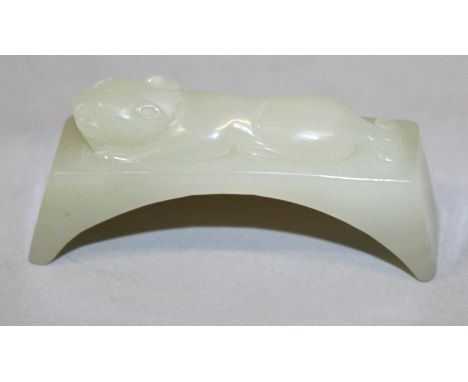 AN UNUSUAL CHINESE CELADON JADE ARCH, surmounted by a chilong, 2.9in wide.