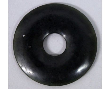 A SMALL CHINESE SPINACH GREEN JADE-LIKE BI DISC, of plain form, 2.1in diameter.