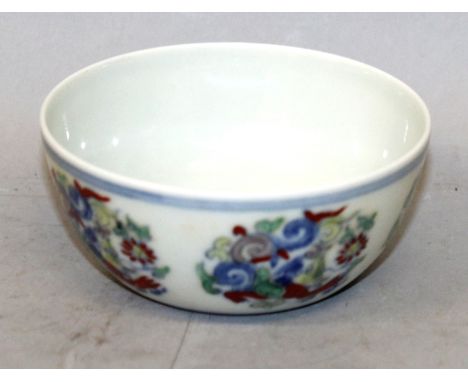 A SMALL CHINESE DOUCAI PORCELAIN BOWL, the sides decorated with repeated alternating floral and scroll arrangements, the base