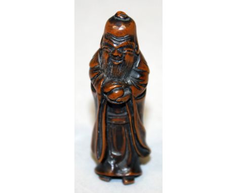 A JAPANESE WOOD SASHI NETSUKE OF FUKUROKUJU, standing in flowing robes and holding a peach, 2.9in high.