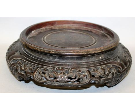 ANOTHER CHINESE CARVED HARDWOOD STAND, with ruyi-form feet, and pierced floral frieze, 10.2in wide, to support a vase with a 