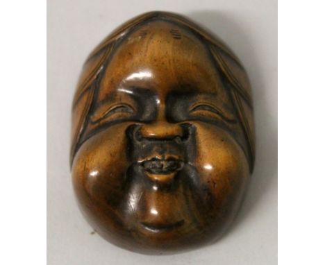 A GOOD QUALITY SIGNED JAPANESE MEIJI PERIOD BOXWOOD MASK NETSUKE OF OKAME, with jovial features, the underside with engraved 