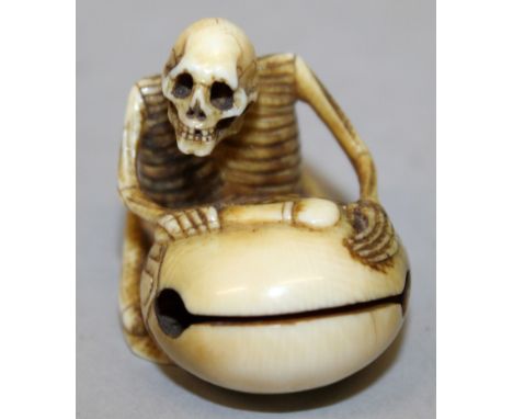 A SIGNED JAPANESE MEIJI PERIOD IVORY NETSUKE OF A SKELETON, kneeling before a temple bell, the base with an engraved signatur