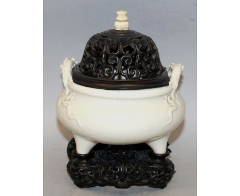 A CHINESE WHITE GLAZED CRACKLEGLAZE PORCELAIN TRIPOD CENSER, possibly early 20th Century, together with a fitted pierced wood