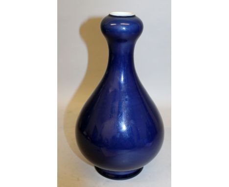 A CHINESE BLUE GLAZED PORCELAIN VASE, with an onion neck, the sides applied with an even glaze, the base with a Qianlong seal