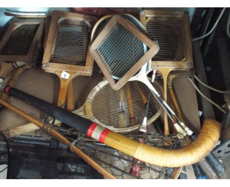 A quantity of old tennis rackets with cases, Badminton  rackets with cases, hockey sticks, Lacrosse stick etc 