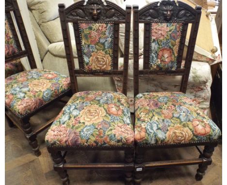 A set of 4 oak framed dining room chairs with lion masks in the backs with tapestry upholstered seats and backs and a pair of